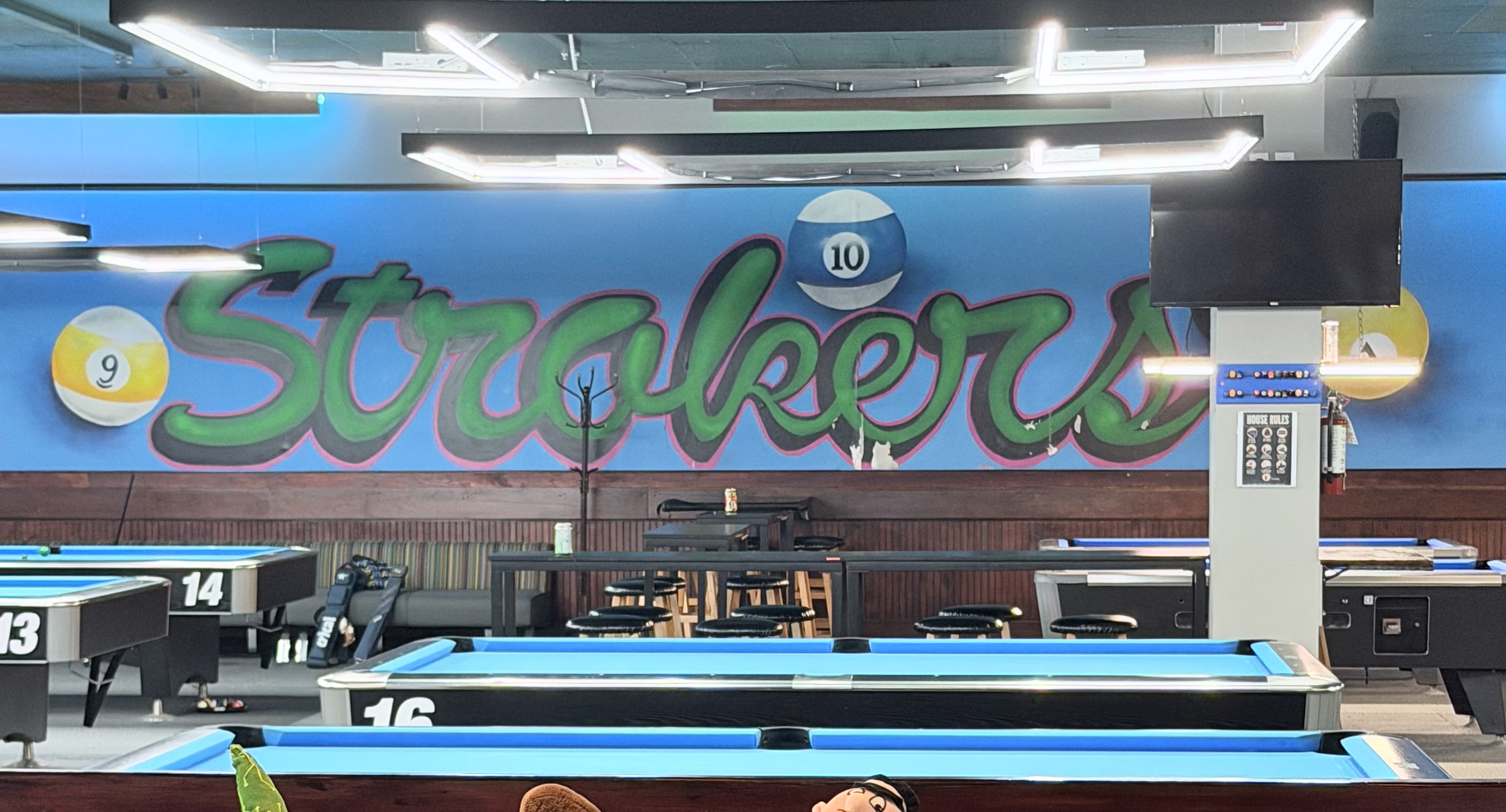 Inside Strokers Billiards - blue-felt tables and the Strokers mural